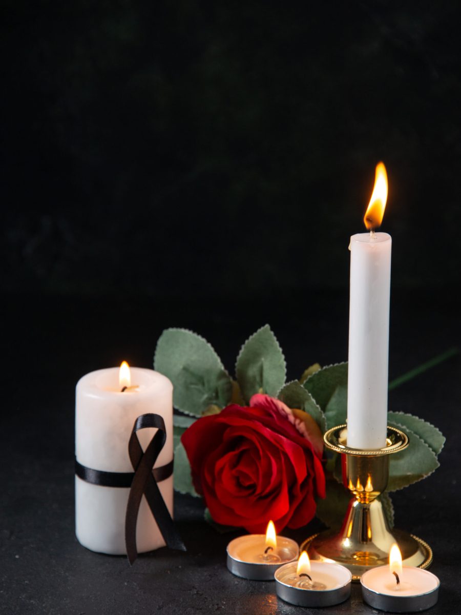 front-view-burning-candles-with-red-flower-dark-surface